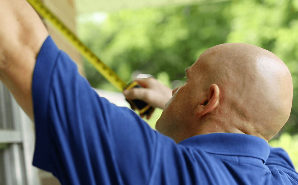 man measures window