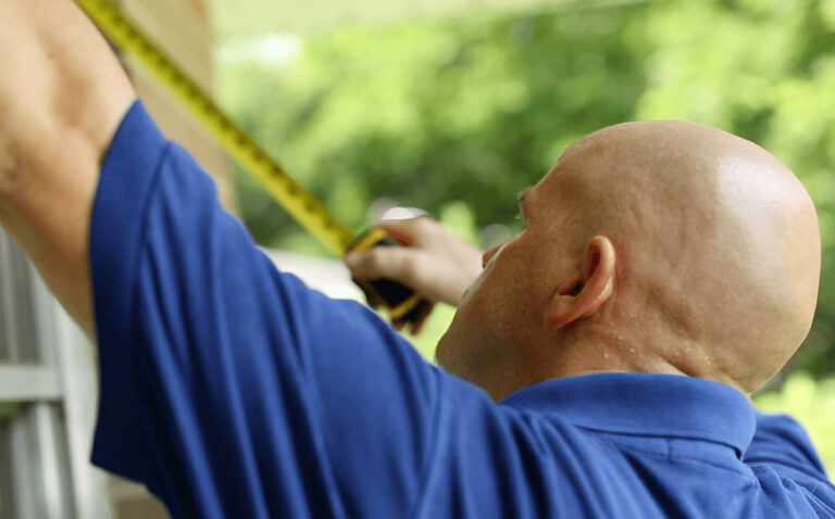man measures window